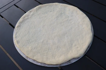 disco de masa de pizza sobre rejilla de aluminio