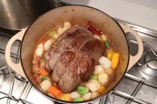 Bonito trozo de carne confitada y verduras fundentes en una cazuela