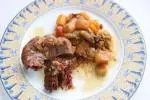 Bonito trozo de carne confitada y verduras fundentes en una cazuela