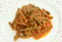 Judías verdes y puré de tomate con cebolla, cubiertos con queso cheddar rallado.