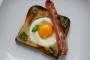 Tostada ahuecada y cubierta con un huevo y una loncha de bacon.